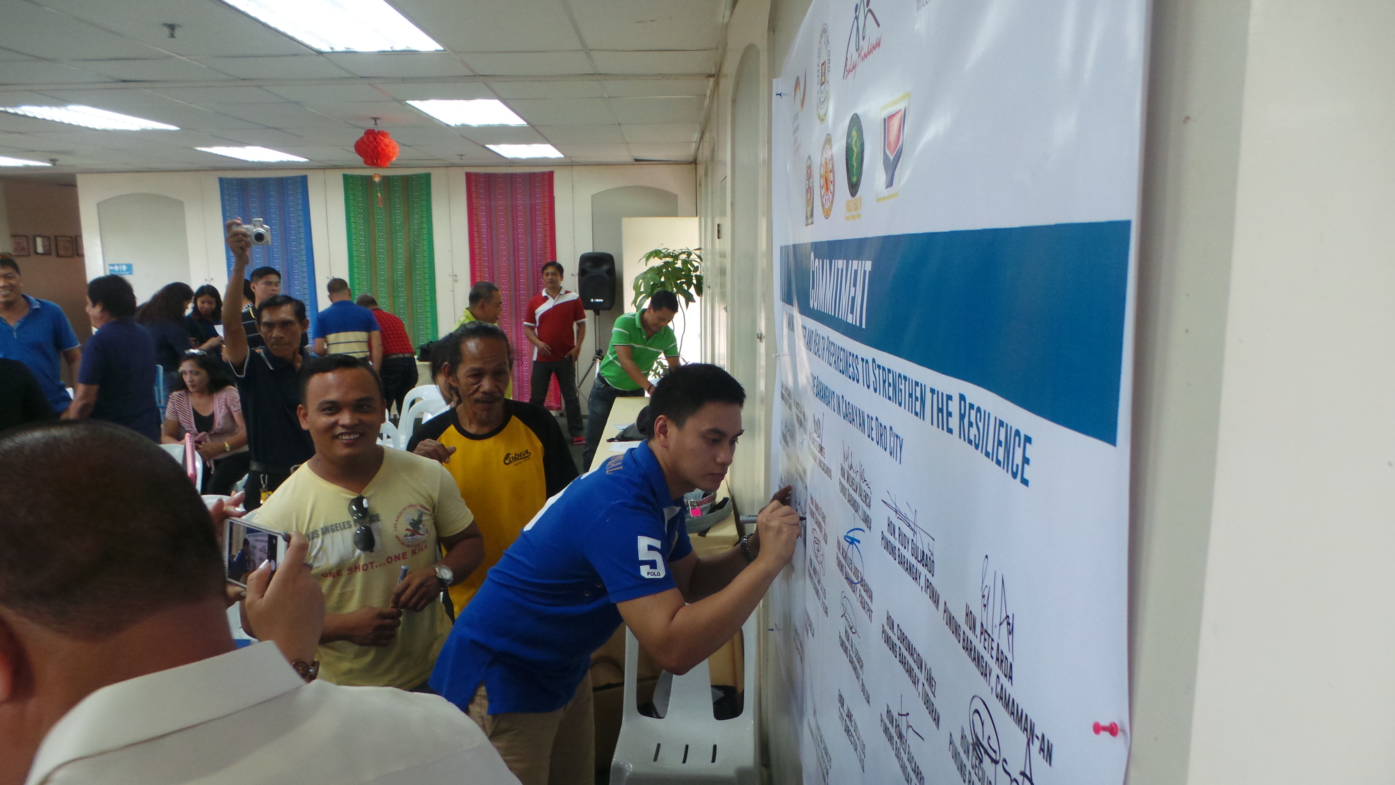 Representatives from the 18 Cagayan de Oro barangays sign the symbolic commitment to the health and resiliency project supported by JUH